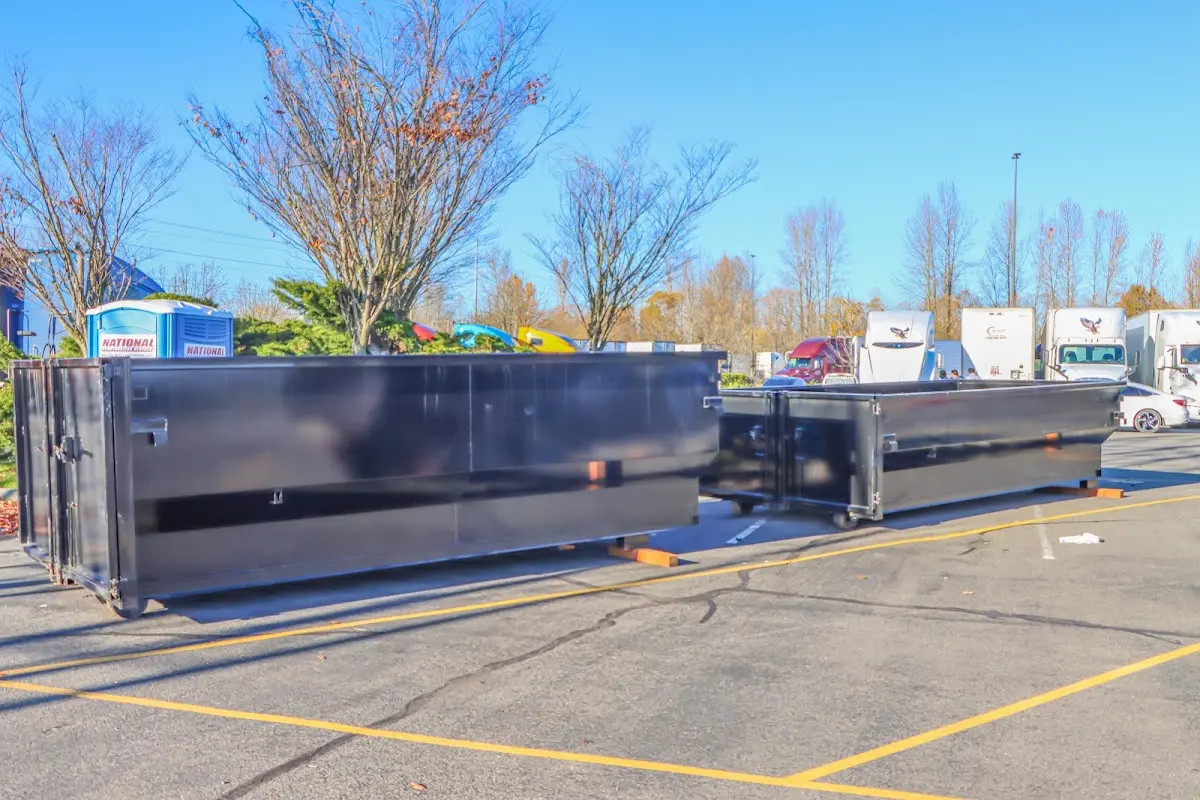 Professional dumpster rental service with roll-off container on residential driveway in Calverton